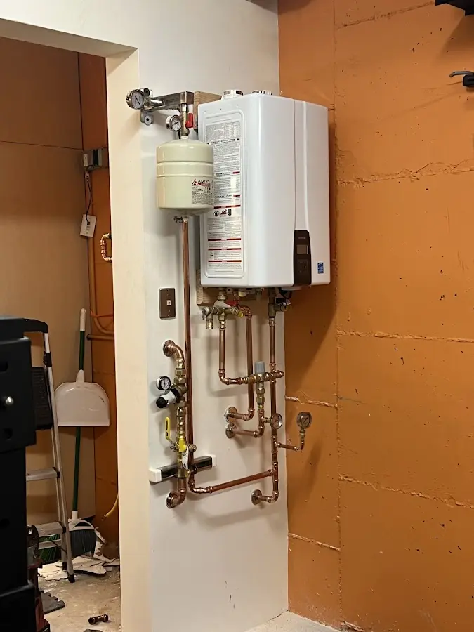 Plumbing technician inspecting water heater connections in Pittsburgh